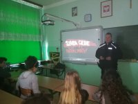 Dzielnicowy omawiający kampanię &quot;Narkotyki i dopalacze zabijają&quot; dla uczniów szkoły w Dziadkowicach