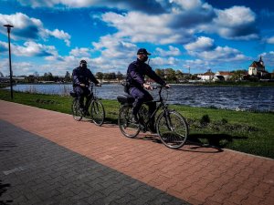 dwóch policjantów patroluje teren przywodny rowerami